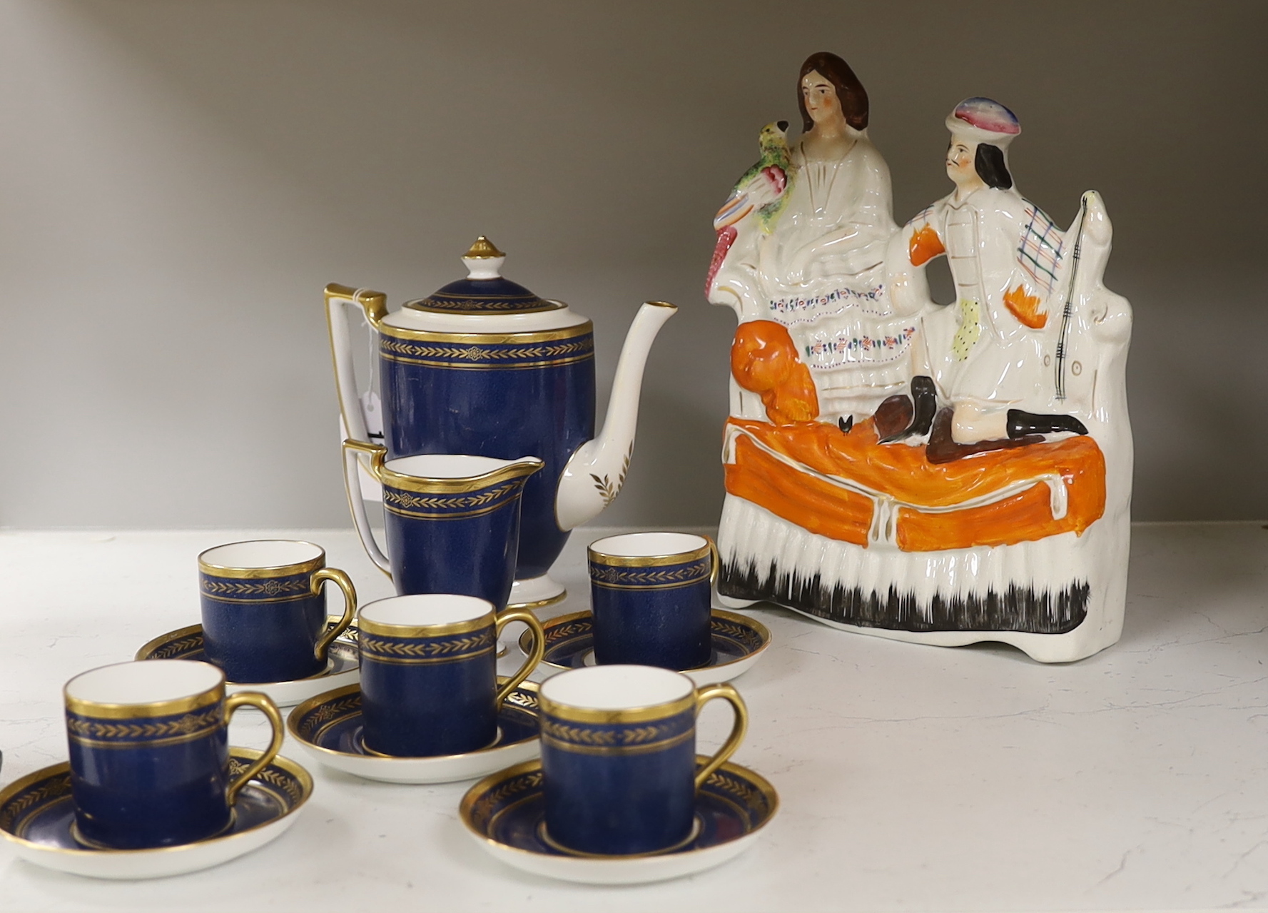 A Mintons powder blue part coffee set comprising six cans and saucers, coffee pot and milk jug together with a Staffordshire flat back figure group, 20cm wide